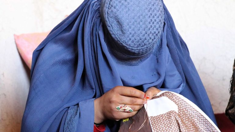 Una mujer afgana trabaja bordando ropa en un taller en Kandahar, Afganistán