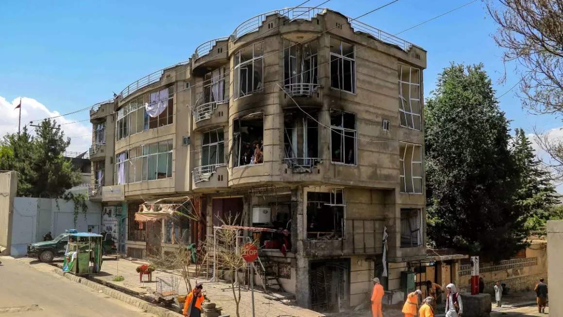 Trabajadores municipales limpian la escena de la explosión frente a un templo sij, en Kabul (Afganistán), el sábado.