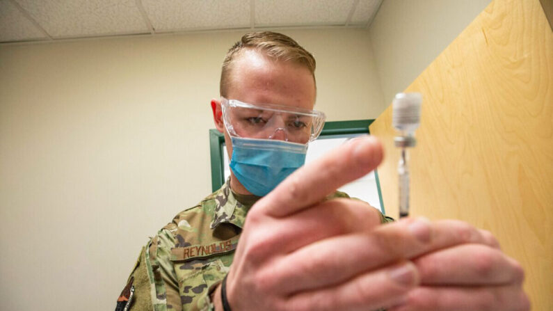 Un sargento de la Fuerza Aérea de Estados Unidos manipula una vacuna COVID-19 de Pfizer en una clínica de Massachusetts el 16 de febrero de 2021. (Joseph Prezioso/AFP vía Getty Images)
