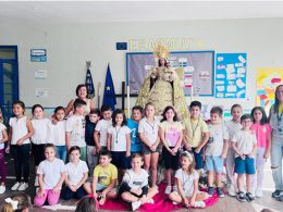 Un grupo de alumnos del CEIP Maestra Caridad Ruiz junto a la Virgen María de La Algaida