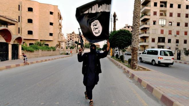 Miembro de Estado Islámico con una bandera durante un desfile militar en la ciudad siria de Raqqa en 2014. /