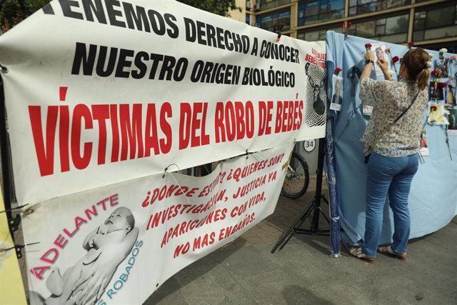 Archivo - Varias personas colocan claveles en un mural colovcado en Madrid con retratos de colaboradores en la búsqueda de víctimas por el robo de bebés en España - Isabel Infantes - Europa Press