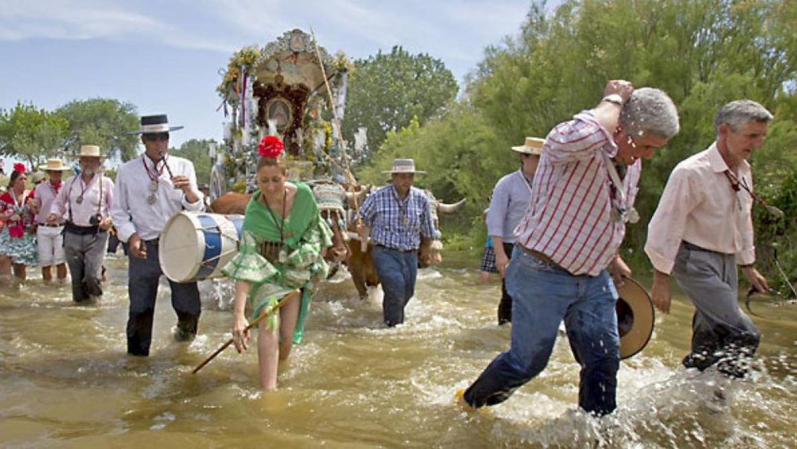 Los rocieros a su paso por el vado del Quema, camino de la aldea de El Rocío. EFE