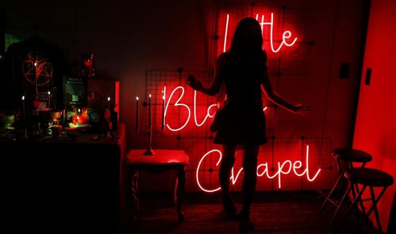 Una persona posa para una fotografía dentro de la Pequeña Capilla Negra en el Satancon 2023 del Satanic Temple.