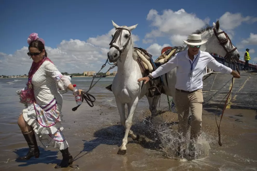Los peregrinos cruzan el río Guadalquivir en ruta hacia el santuario de El Rocío en el parque nacional de Doñana durante la peregrinación anual de El Rocío. — Jorge Guerrero / AFP