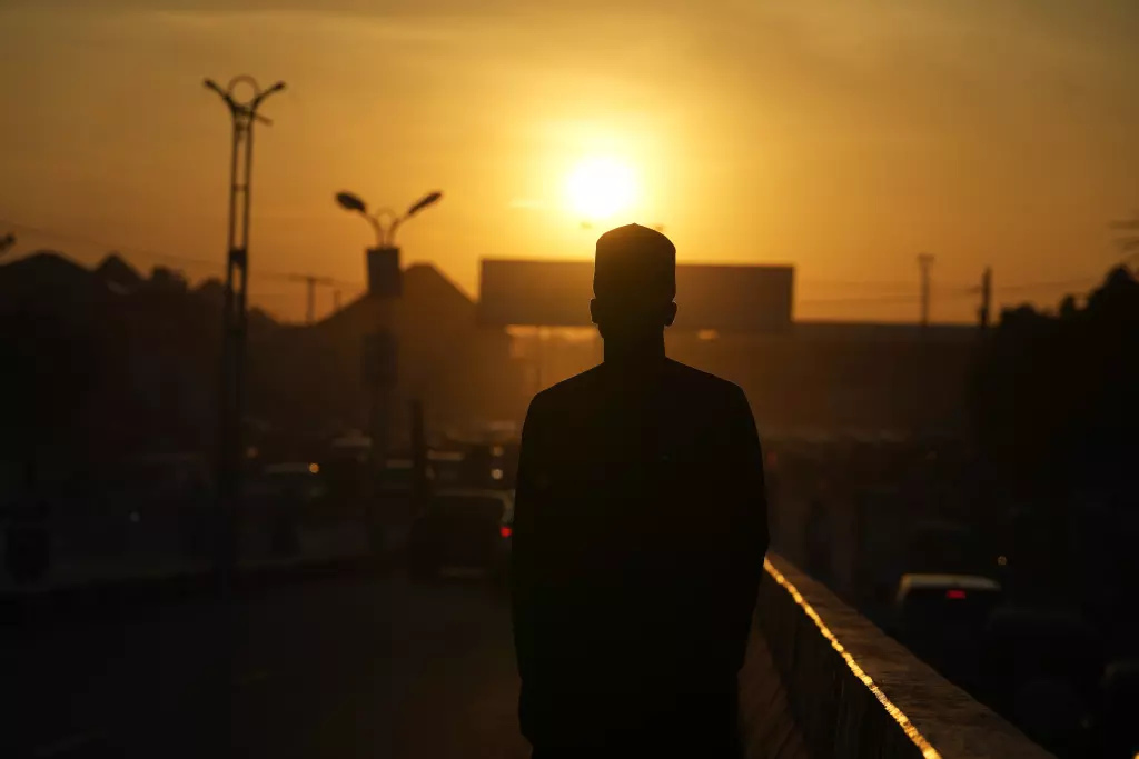 La silueta de una persona atea se recorta contra el sol durante el atardecer en una calle en Kano, Nigeria, el 14 de julio de 2023. Los no creyentes en Nigeria dijeron que siempre han sido tratados como ciudadanos de segunda clase en el país profundamente religioso, cuya población de 210 millones está dividida casi en partes iguales entre cristianos —que predominan en el sur— y musulmanes, que son mayoría en el norte. Algunos afirman que las amenazas y los ataques han empeorado en el norte desde que el líder de la Asociación Humanista de Nigeria, Mubarak Bala, fue arrestado y encarcelado por blasfemia. (AP Foto/Sunday Alamba) (Sunday Alamba / Associated Press)