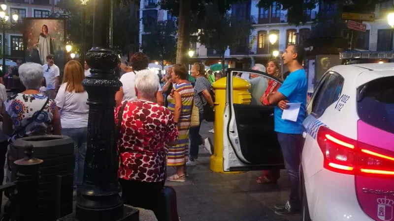 El portavoz de los grupos de rezo que uso la megafonía, junto al coche patrulla y a las personas participantes en el "rosario por la vida" Imagen cedida
