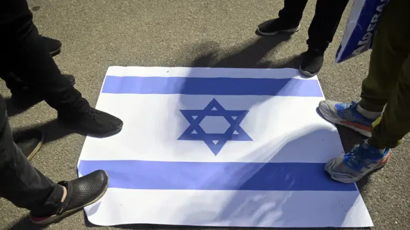Militantes de Hizbulá pisotean la bandera israelí en una manifestación en Beirut. EP
