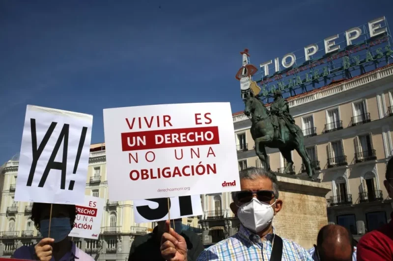 Un grupo de personas sostiene pancartas y carteles durante una concentración por la muerte digna en Madrid, a 25 de junio de 2021. — Cézaro De Luca / Europa Press