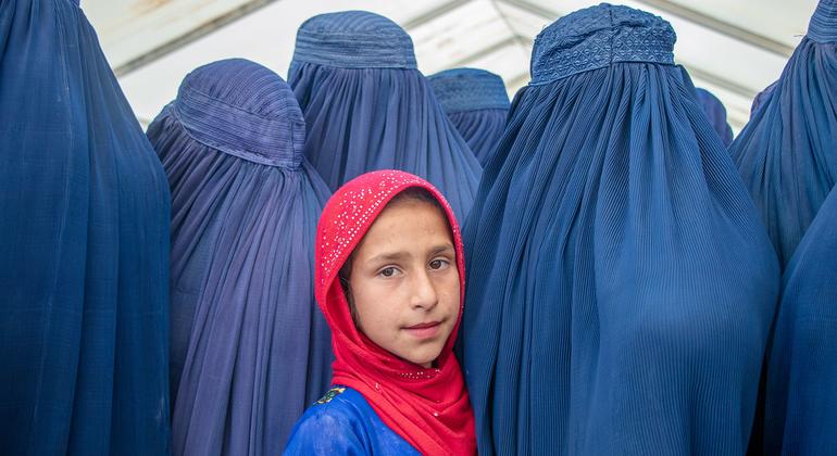 Una niña con velo rodeada de mujeres con burka o niqab en Afganistán © UNICEF/Osman Khayyam